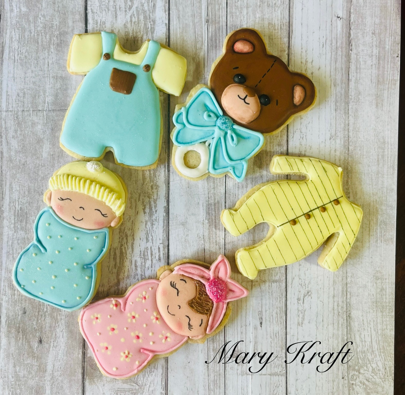 Pastel baby shower cookies with bears, sleepers, and swaddled babies